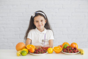 portrait-girl-with-colorful-ripe-fruits-desk